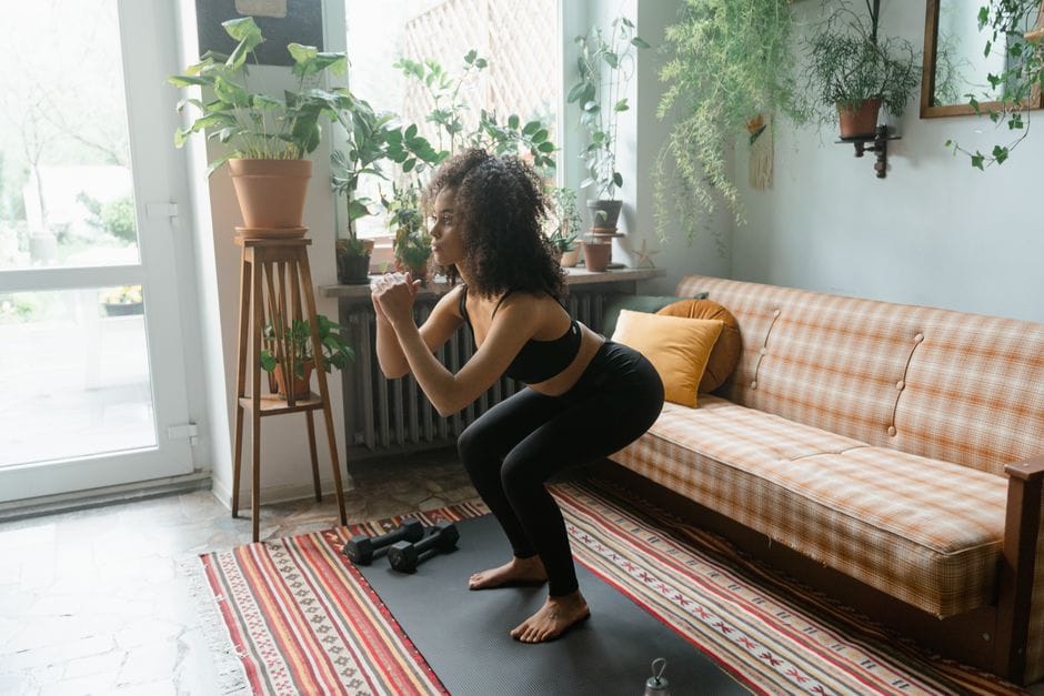 woman performing bodyweight squat workout at home