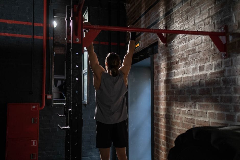 Person practicing a dead hang on a pull-up bar