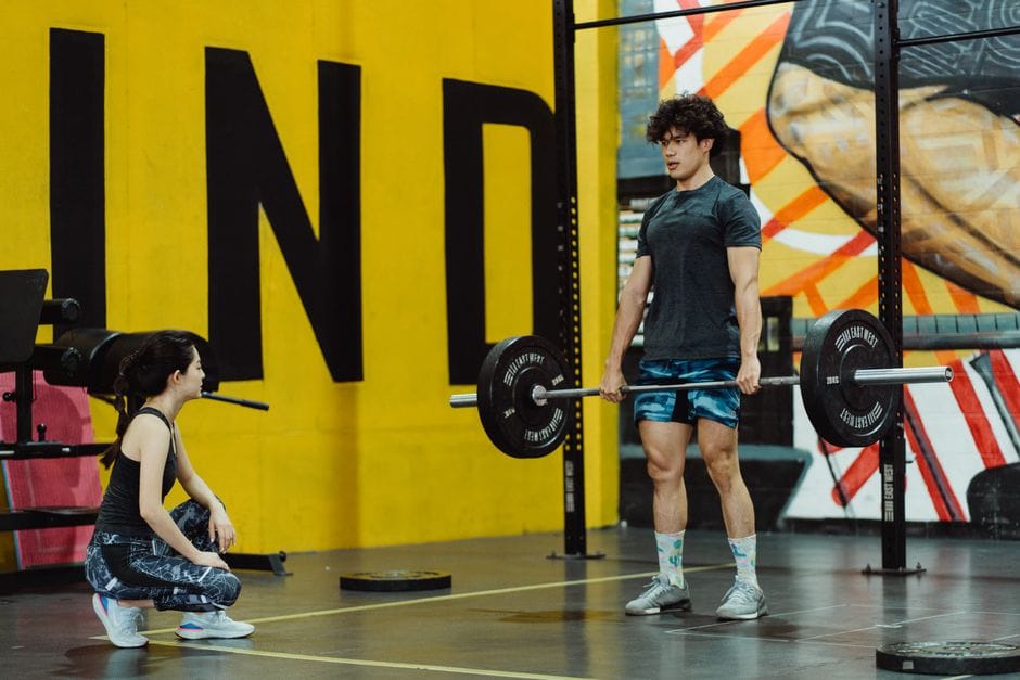 Man performing a barbell Romanian deadlift with a flat back and hips pushed back