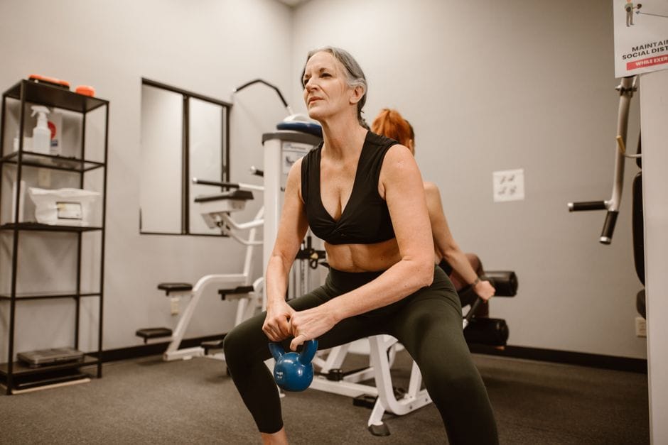 Woman performing a kettlebell goblet squat with the weight held at chest height