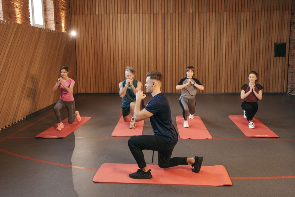 Person performing a kneeling hip flexor stretch on a yoga mat