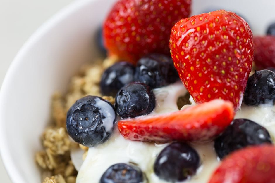 bowl of greek yogurt topped with berries and granola