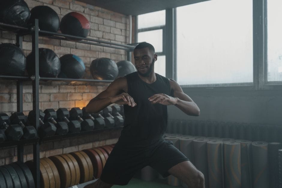 African American man engaged in a workout with gym equipment around him, promoting fitness.