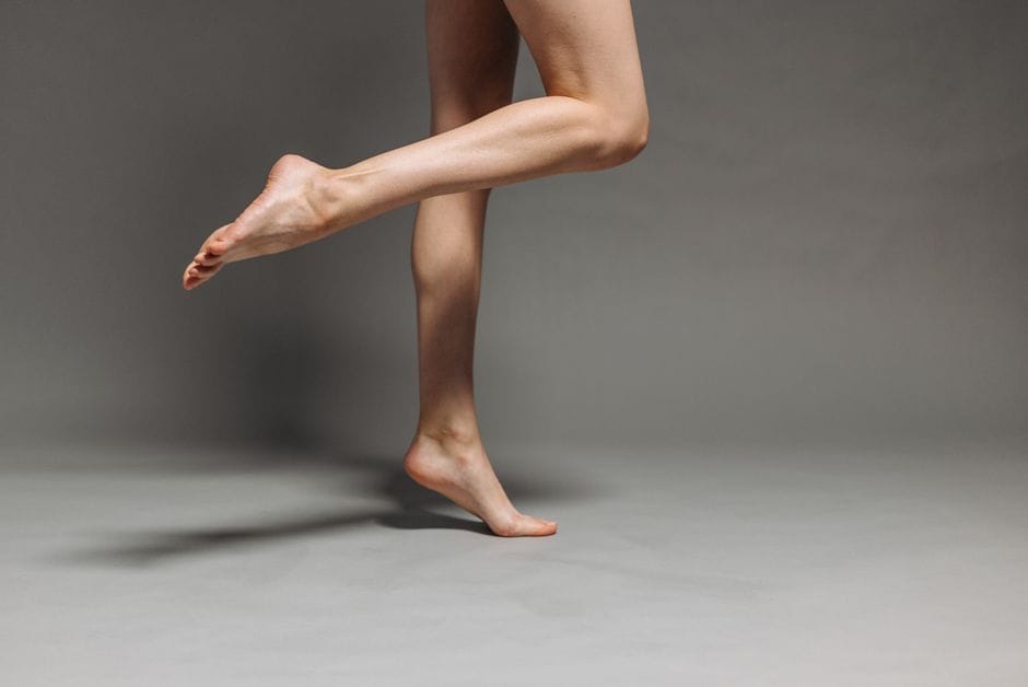 Close-up of feet in the raised position of a calf raise, balancing on toes