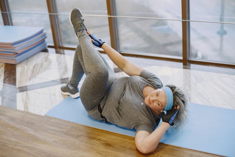 Person lying on back performing a dead bug with opposite arm and leg extended
