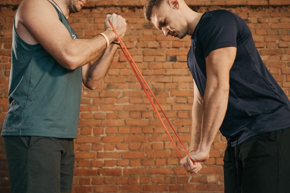 Person doing a face pull exercise with a resistance band at home
