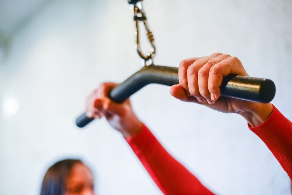 Close-up of a lat pulldown machine cable and bar attachment