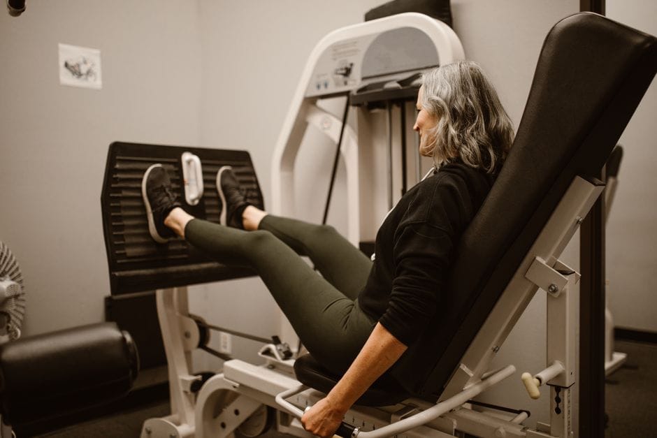 Person performing a leg press with feet shoulder-width apart on the platform